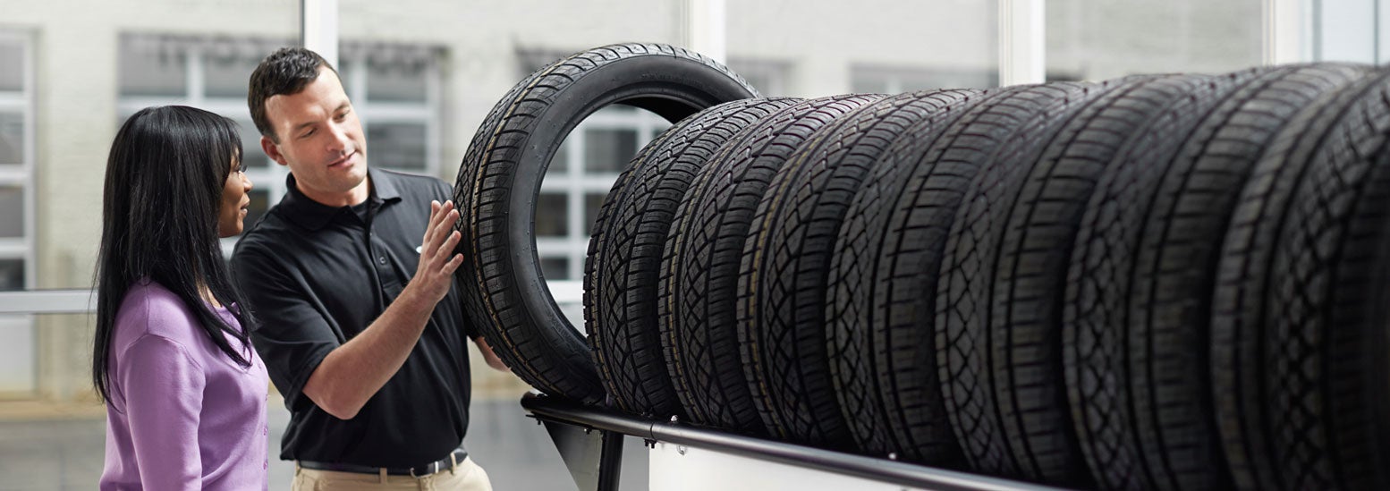 Subaru service representative showing customer a tire. | Competition Subaru of Smithtown in St James NY