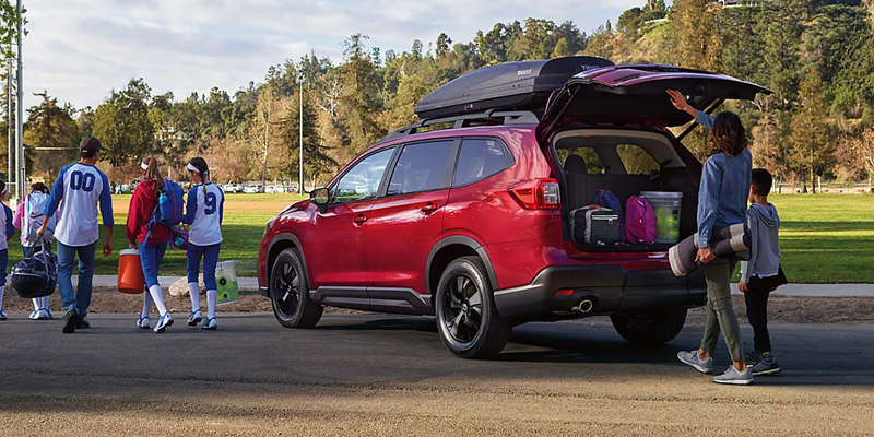 Red Ford Explorer SUV parked with the rear liftgate open and cargo area loaded with gear