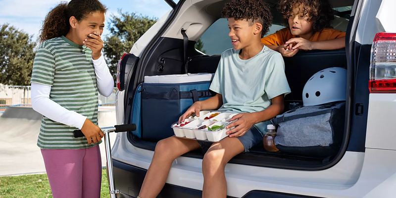 The rear cargo area of a light-colored SUV is open