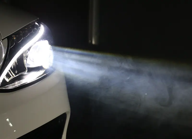 Vehicle headlight illuminating the road ahead at night, highlighting headlight performance