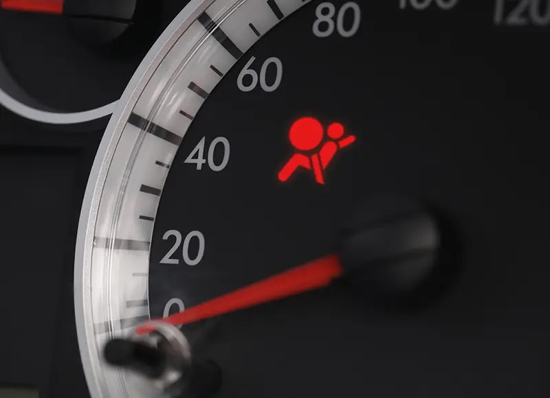 Airbag warning indicator illuminated on a vehicle instrument cluster, signaling a potential issue