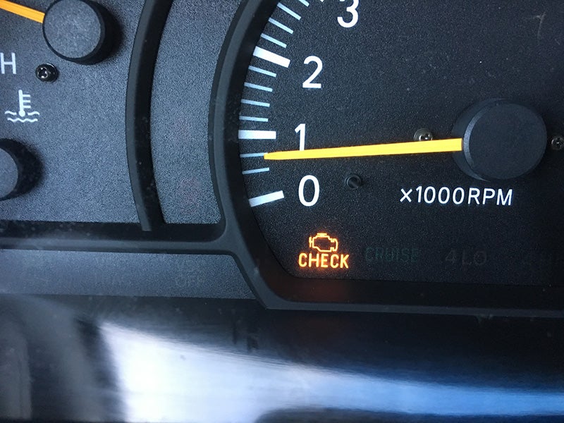 vehicle instrument cluster with the Check Engine warning light illuminated
