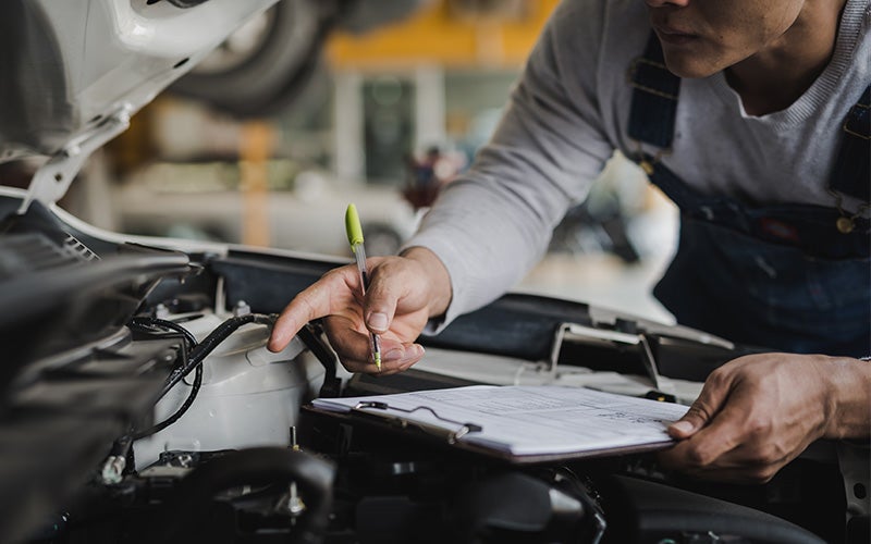 A close-up view of a vehicle being inspected in a workshop or garage