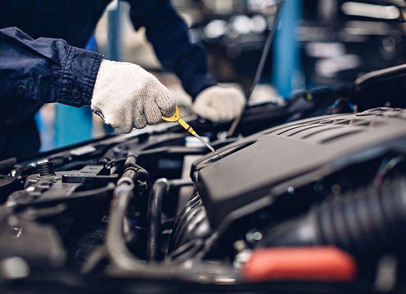 Technician checking vehicle engine components